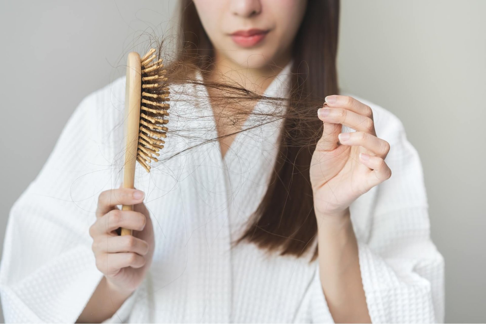 Woman with thin hair holding brush